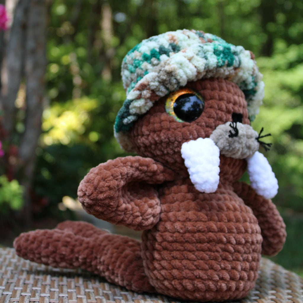 Crocheted animal figure with a hat in a natural setting